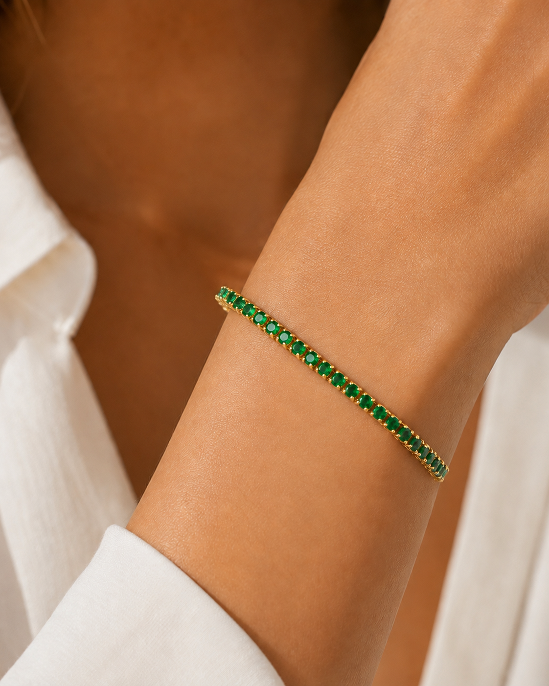 Model wearing gold-plated green tennis bracelet, 6-inch size