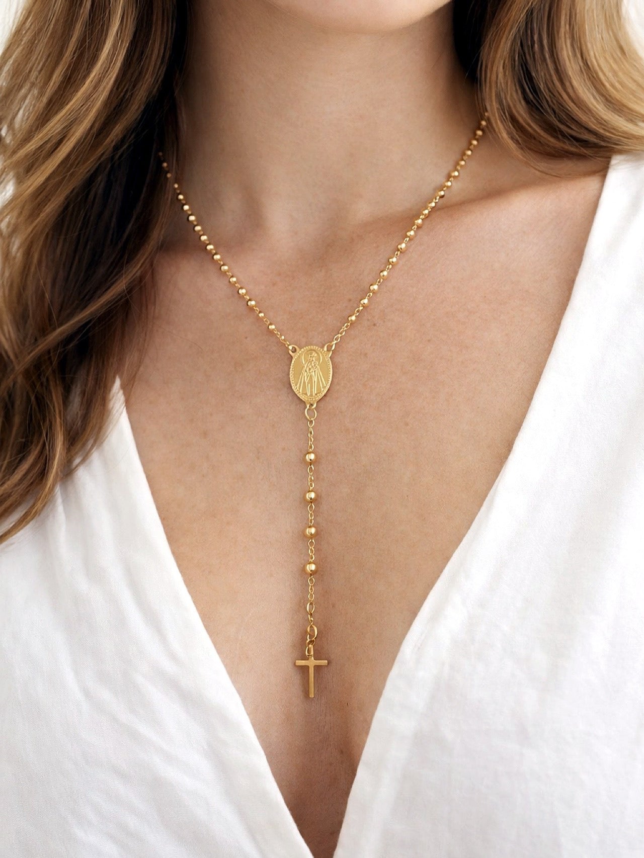 Woman wearing a gold-filled Virgen del Carmen rosary necklace