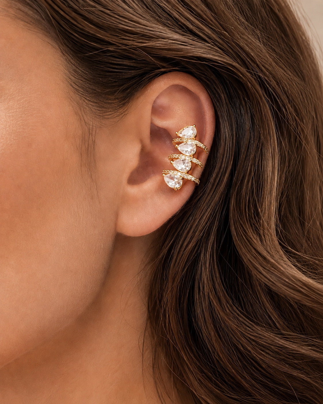 Model wearing COMPLIMENTI gold-tone clear teardrop ear cuff