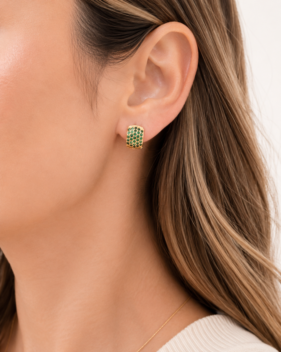 Model wearing COMPLIMENTI gold-plated green pavé square huggie earrings, 1 cm