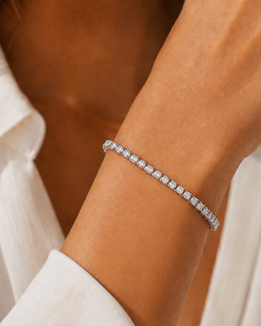 Model wearing COMPLIMENTI gold-plated silver-tone clear tennis bracelet, 6-inch