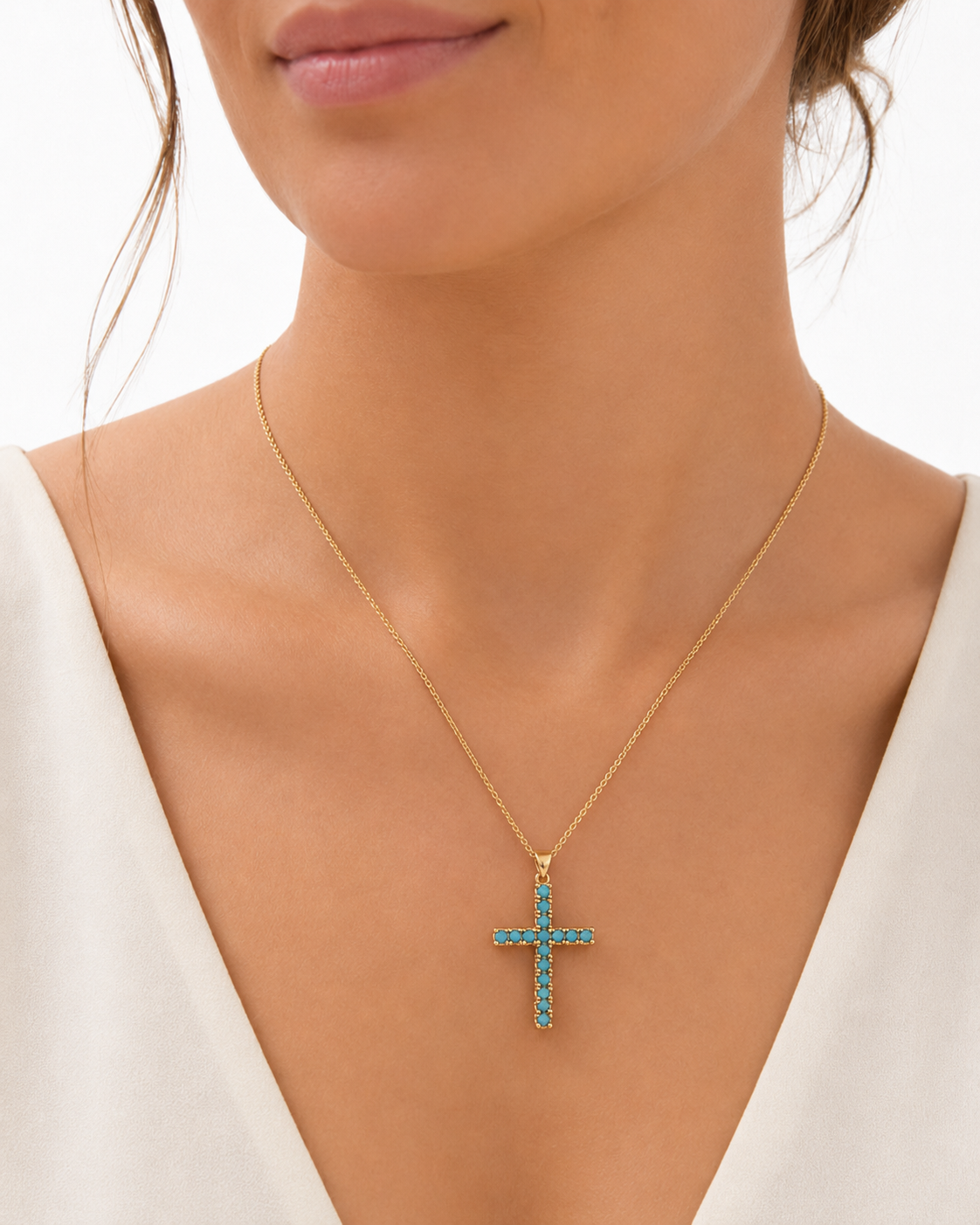 Woman wearing an 18-inch gold-plated turquoise cross necklace