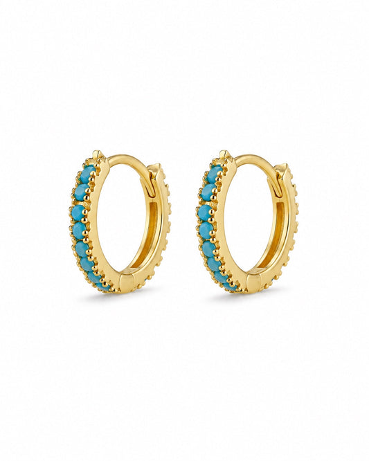 Gold-plated turquoise huggie earrings on white background