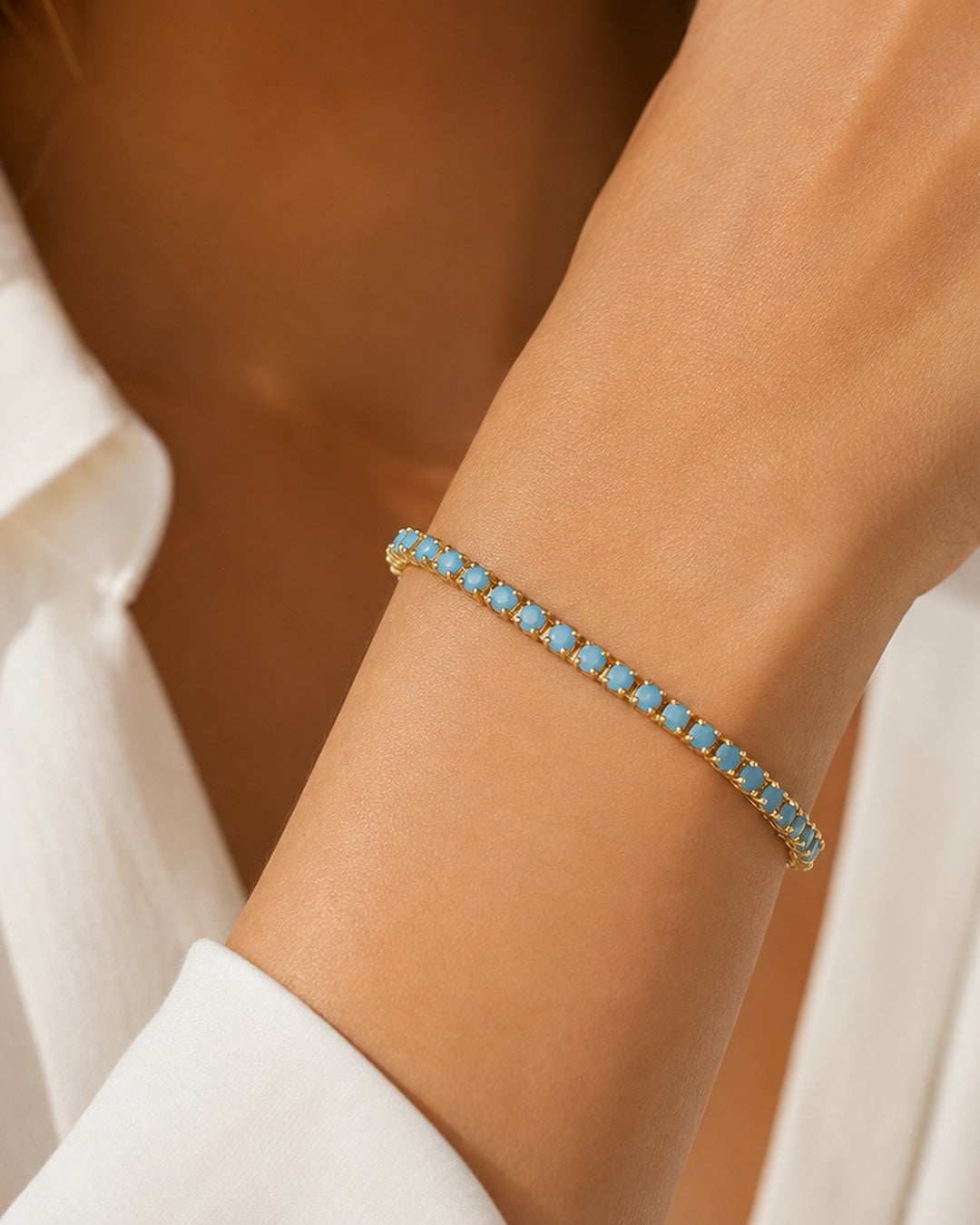 Model wearing gold-plated turquoise tennis bracelet, 6-inch size