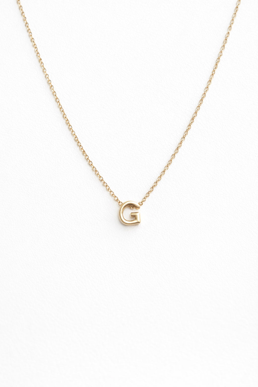 Personalized gold-plated initial necklace on white background